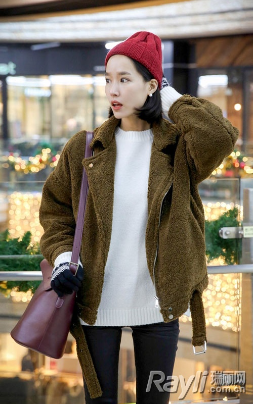 棕色羊羔毛机车夹克搭配白色针织衫、黑色紧身裤和红色针织帽.